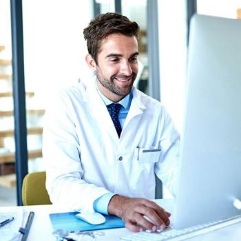 Security male doctor working on a desktop computer