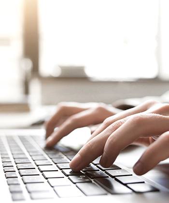 close up of hands typing on a keyboard