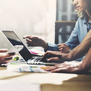 Content Services: The key to unlocking efficiency people working on laptop and mobile